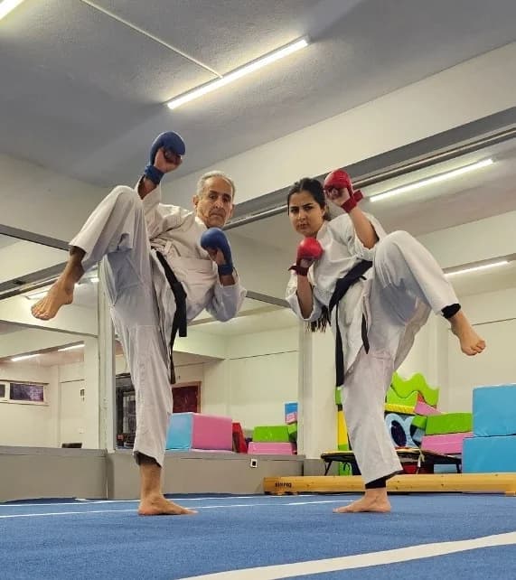 Sensei Behzad ve Sensei Homa Yaghoubian, Kartal Yakacik Spor Kulubu'ndeki karate antrenmaninda es zamanli yuksek tekme calisirken
